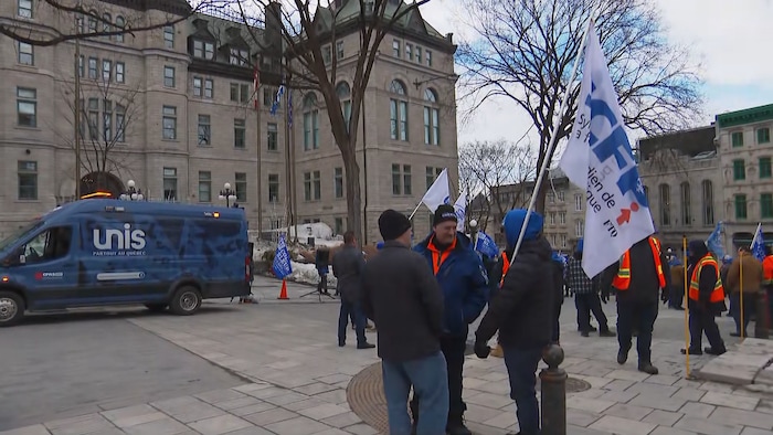 Des cols bleus manifestent devant l'hôtel de ville de Québec.