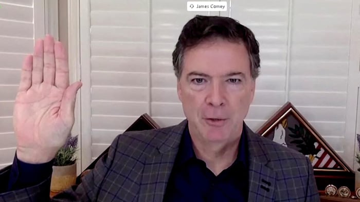 Capture d'écran de James Comey, qui témoigne par visioconférence en levant la main pour prêter serment.