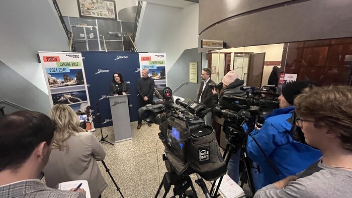 De nombreux journalistes assistent à une conférence de presse. 