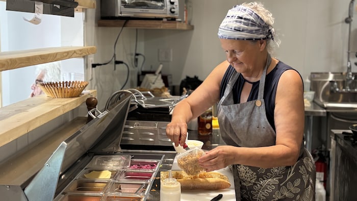 Une femme prépare un sandwich.