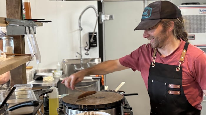 Le propriétaire du café qui prépare des crêpes.
