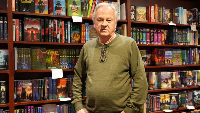 Michael Neill devant une étagère de livres de la librairie Mosaic Books, à Kelowna le 12 janvier 2026.