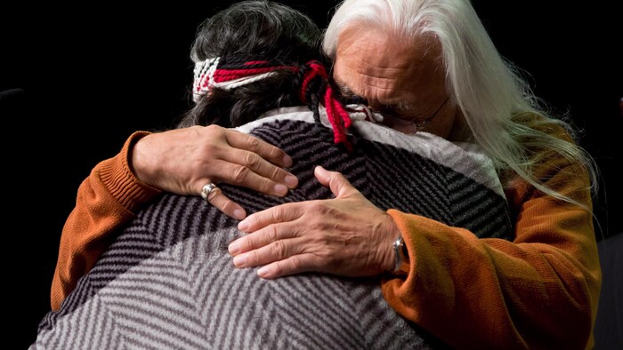 Les survivants Joe George (droite) et Marie George (gauche) s'embrassent pendant un événement de la Commission à Vancouver.