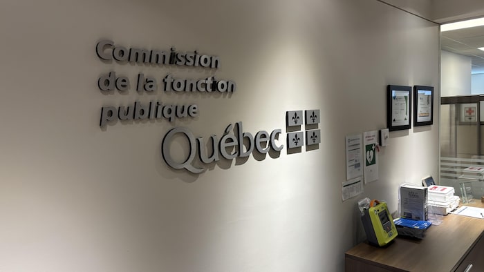 Le loge de la Commission de la fonction publique posé sur le mur d'un bureau.