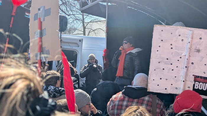 Patricia Paquin devant une foule de manifestants.
