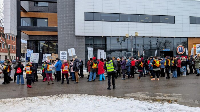 Des manifestants font du bruit devant un bâtiment de la rue Racine à Chicoutimi. 