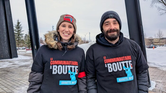 Une femme et un homme prennent la pose à l'extérieur en hiver. 