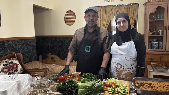 Abdelilah Hamdache et sa femme, Latifa Gdid, derrière une tablée remplie de nourriture.