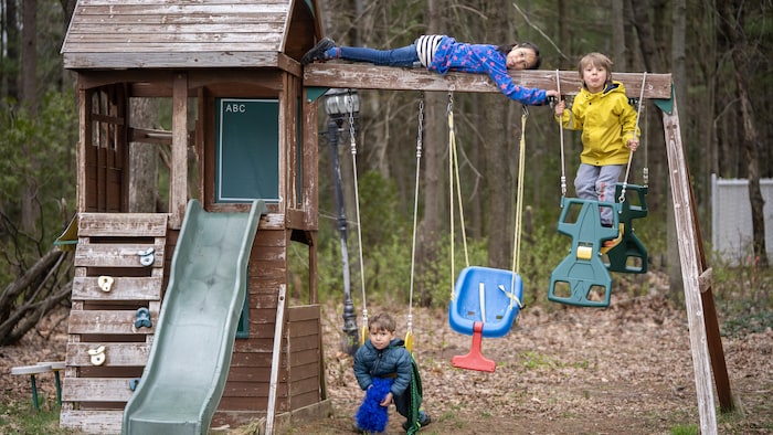 Trois enfants dans un module de jeux.