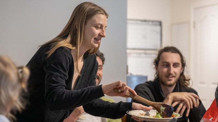 Une femme se sert une portion de nourriture.