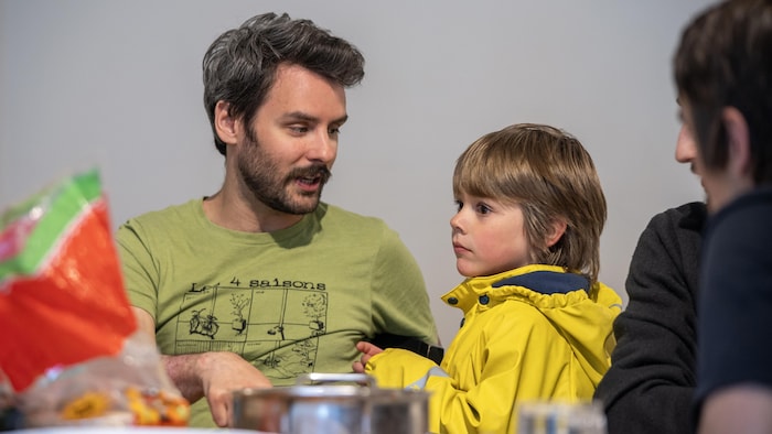 Un homme parle avec un enfant.