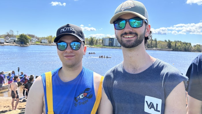 Deux jeunes hommes devant une rivière.