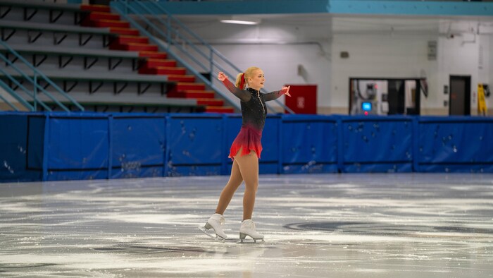 Une patineuse se tient sur la glace