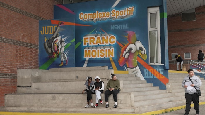 Des adolescents devant l'entrée du centre sportif de la cité de Franc-Moisin.