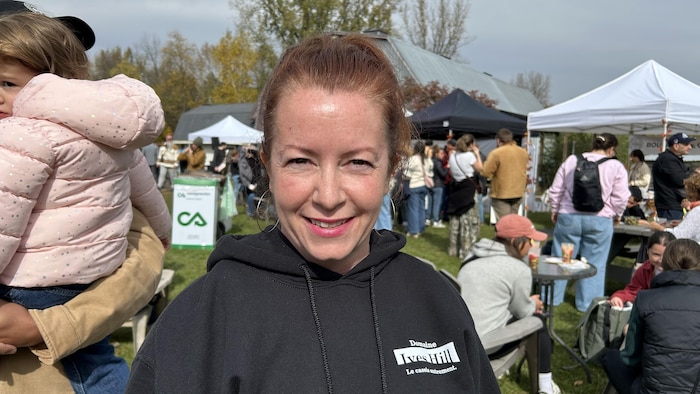 Lise Pratte sourit avec en arrière-plan les clients des Comptonales.