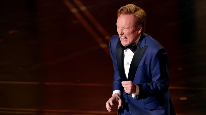L'animateur des Oscars fait une grimace sur scène. 