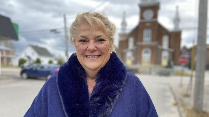 Ginette Desbiens pose devant l'église.