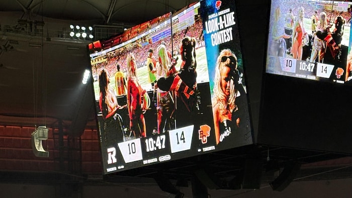 Heidi, en maillot de bain rouge, la gagnante du concours de sosies sur le grand écran du stade BC Place.