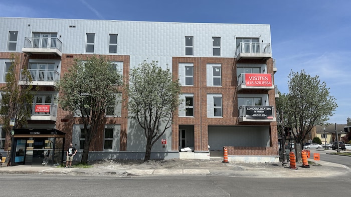 Une affiche « condos locatifs » sur une immeuble.