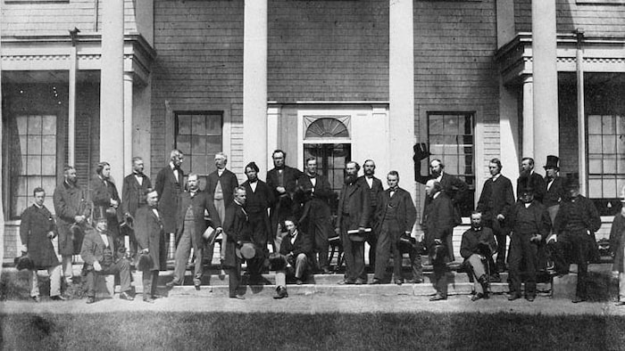 Black and white photo showing the Fathers of Confederation seated.