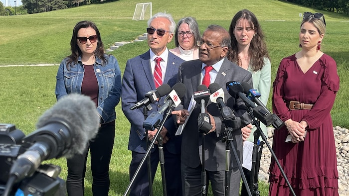 Des personnes en conférence de presse.