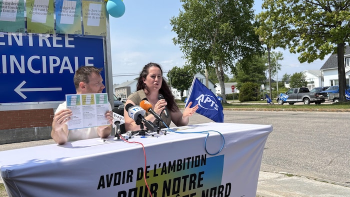 Assis à une table, Kevin Newbury tient un dépliant pendant que Mylaine Larocque parle lors d'une conférence de presse.
