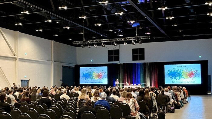 Des professionnels de la santé réunis à Calgary discutent de la santé des réfugiés 2 Des personnes assises sur des chaises lors d'une conférence.