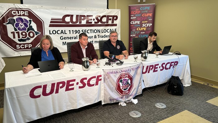 Quatre personne en conférence de presse.