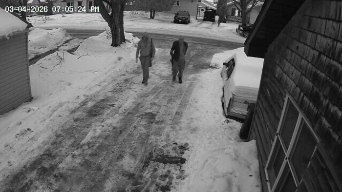Deux hommes marchent dans une rue.