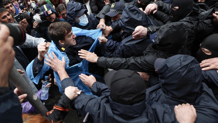 A protester is arrested by officers. 