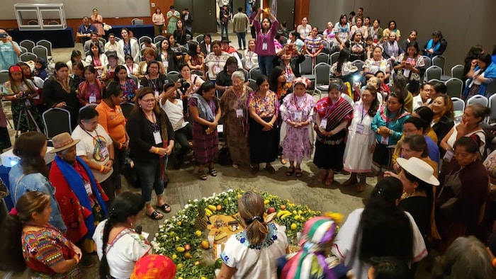 Une salle de congrès avec des femmes en cercle.