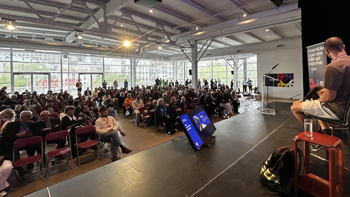 Deux personnes sur une scène devant une foule.