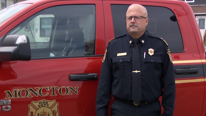 Conrad Landry devant un camion de pompier de la ville de Moncton.