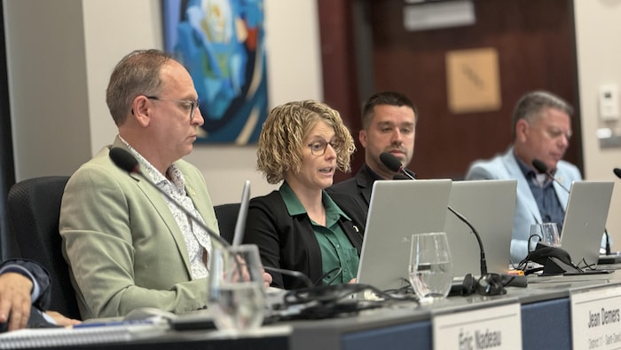 Anick Tremblay assise devant son micro et son ordinateur portable lors d'une séance du conseil municipal de Lévis.