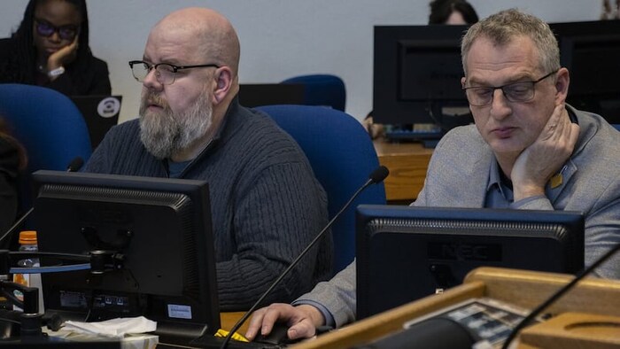 Shaun Cameron à gauche et Bruce Luebke à droite assis devant leurs ordinateurs.