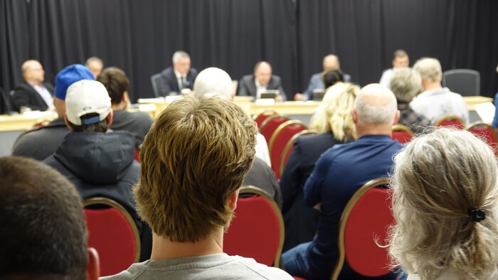 Des citoyens assis de dos dans la salle du conseil municipal des Îles-de-la-Madeleine.