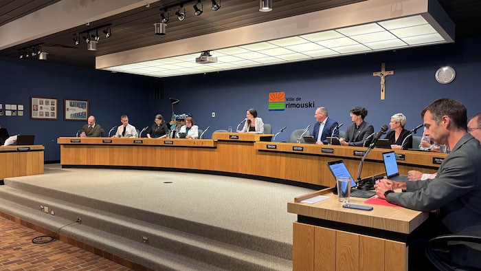 Les conseillers municipaux sont assis à la table du conseil municipal.
