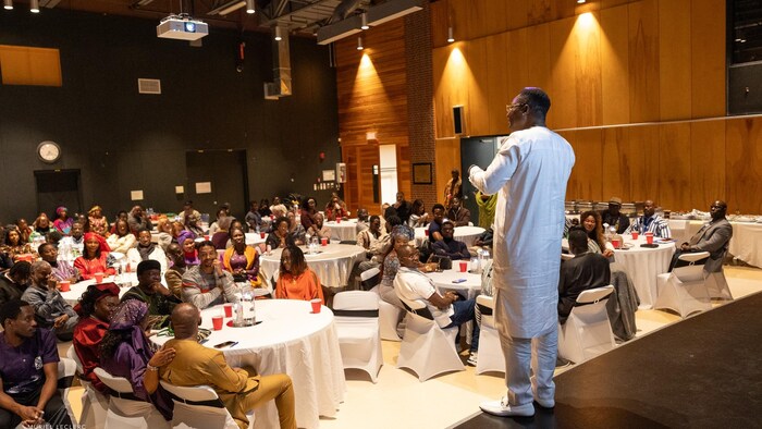 Un orateur s’adresse à un parterre d’invités lors d’un événement organisé par le Conseil panafricain de Québec.