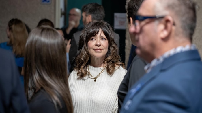 Nancy Sabourin est entourée de plusieurs personnes.