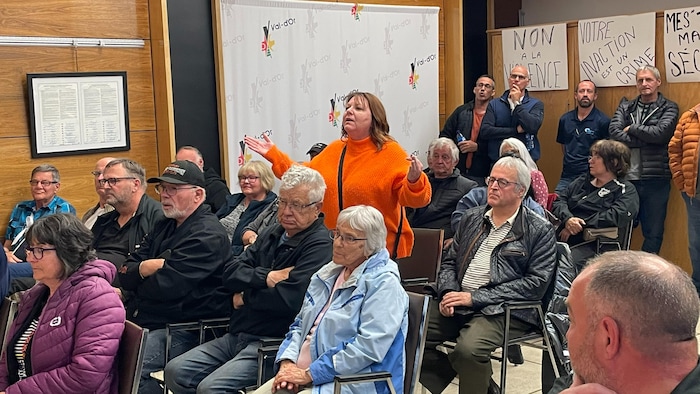 Une femme est debout pour s'adresser aux élus de Val-d'Or. Des dizaines de citoyens l'écoutent.