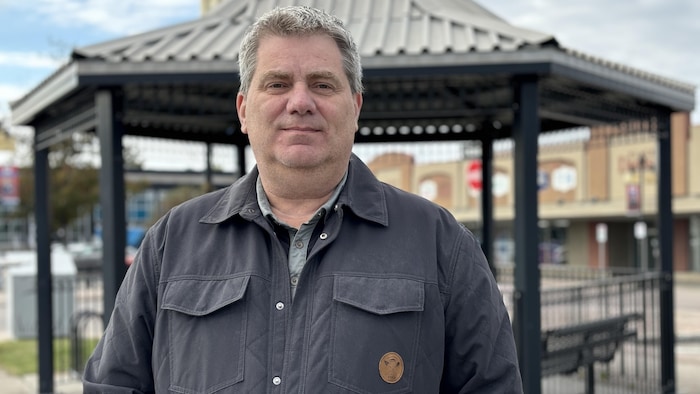 Carl Dufour pose devant un pavillon.