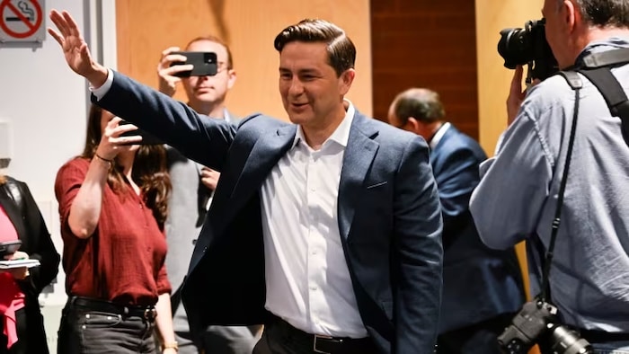 Federal Conservative Party Leader Pierre Poilievre waves as he enters a caucus meeting prior to the Conservative convention in Quebec City. (Jacques Boissinot/The Canadian Press)