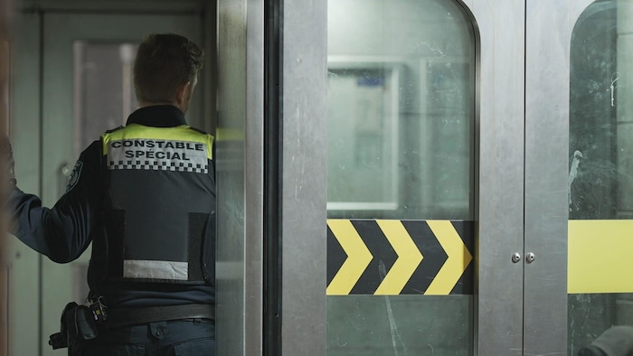 Un constable entre dans le métro.