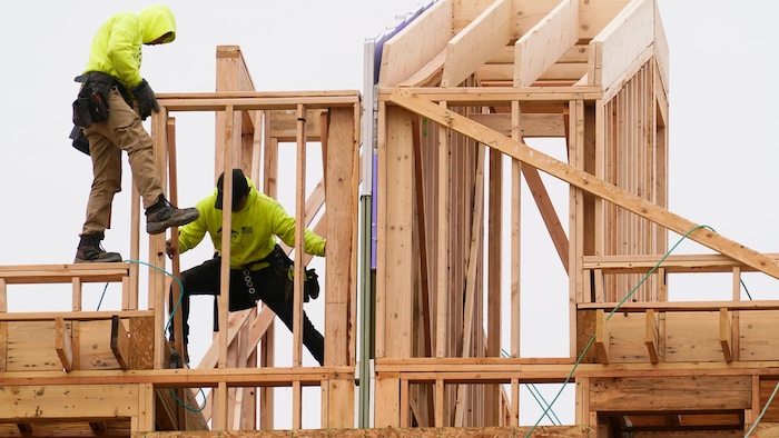 Deux personnes construisent une maison avec du bois d'œuvre, le 5 avril 2022, à Philadelphie.