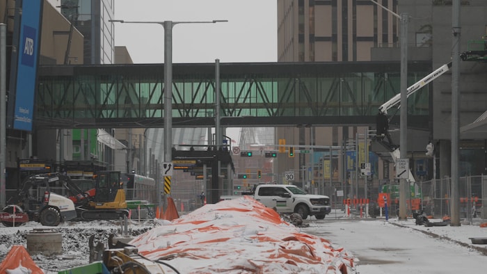 Un chantier de construction donne sur une passerelle piétonne intérieure. 
