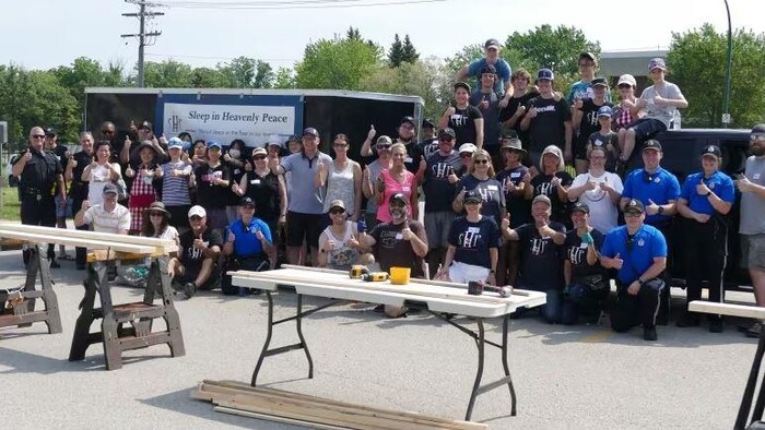 Un groupe de personnes sur une photo de famille, avec à l'avant-plan des tables de travaux.