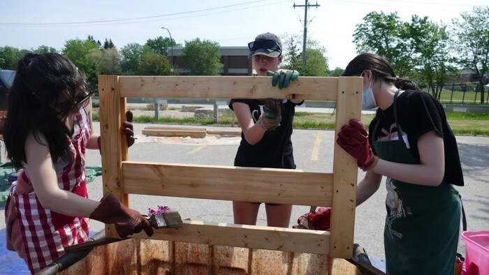 De jeunes tiennent des planches, debout.