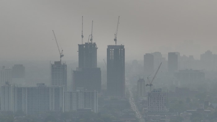 Images aériennes de l'horizon de la ville de Toronto (ouest) recouvert d'une épaisse couche de smog, due à la fumée des incendies de forêt dans les prairies. Une alerte à la qualité de l'air est en vigueur.