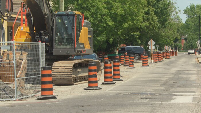 Un détour au bord d'une route mis en place pour un chantier de construction et dans lequel se trouve un engin mécanique.