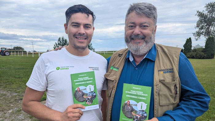Jonathan Buitrago et Nicolas Bellier sourient à la caméra en montrant un dépliant.